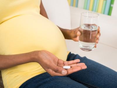 Pregnant woman taking pill