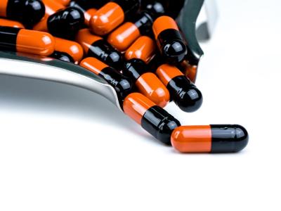 Orange and black capsules on production line