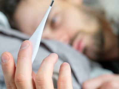 Sick man with thermometer