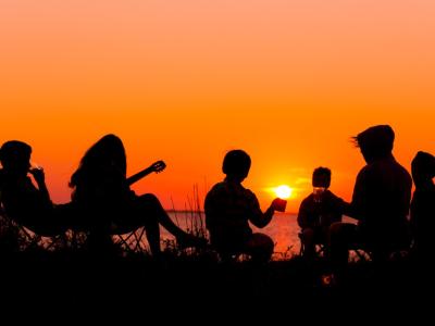 Teens at camp at sunset in silhouette