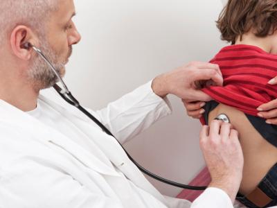 Doctor using stethoscope on boy