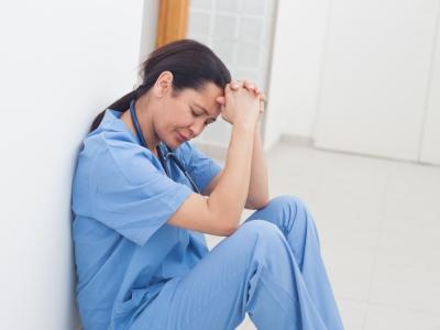 Stressed-out nurse sitting on floor