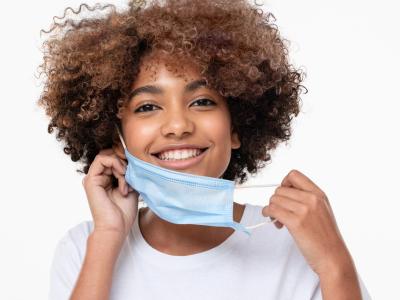 Teen girl taking off mask