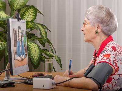 Older woman telemedicine wearing blood pressure cuff