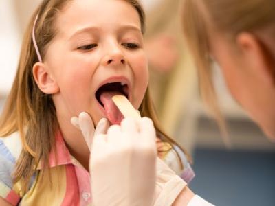 Doctor examining girl's throat
