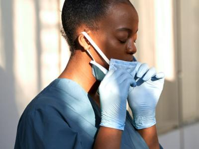 Tired nurse taking mask off