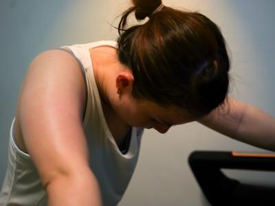 Tired woman leaning on treadmill