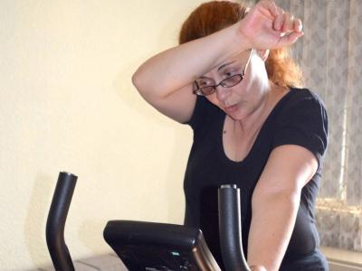 Tired woman on exercise bike