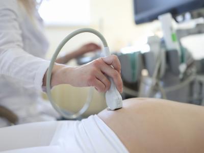 Ultrasound device on pregnant woman's belly