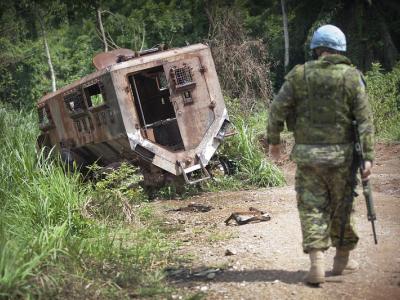 UN soldier with destroyed troop truck