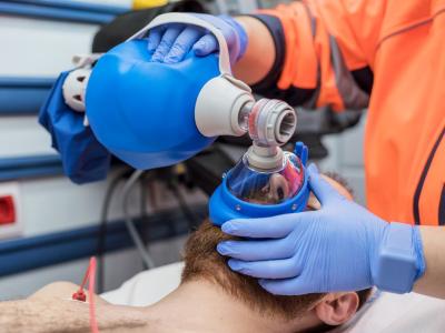 Paramedic using ambu bag on patient