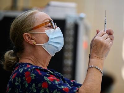Vaccinator holding up syringe