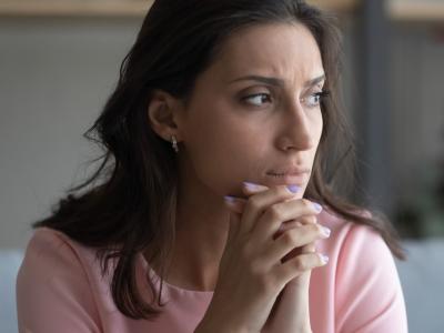 Woman appearing pensive and anxious