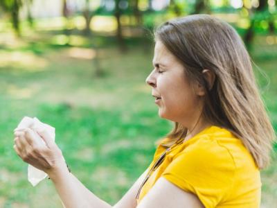 Woman sneezing outdoors