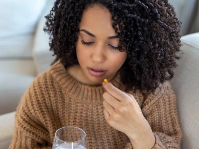 Woman taking drug capsule