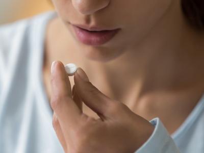 Woman taking white pill