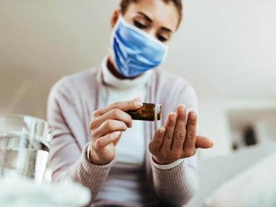 Woman with mask taking pills