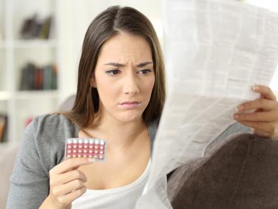 Woman with pill packet and long instruction sheet