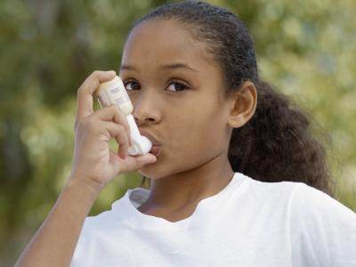 Young girl using inhaler
