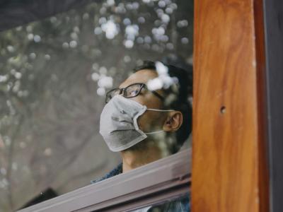 Young man wearing mask in window