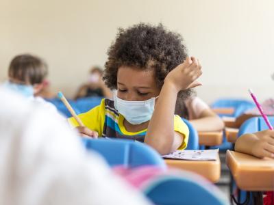 Young student wearing mask in classroom