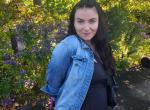 Woman in a jean jacket outdoors. 