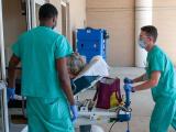 Nurses rolling patient into hospital amid COVID