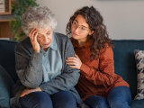 Daughter comforting confused mother