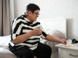 Woman sitting on bed taking medication