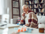 Man wrapped in blanket, coughing