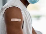Mans arm with vax bandaid