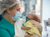 Nurse holding baby in hospital