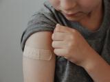 Boy with Band-Aid on arm after vaccination