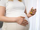 Pregnant women holding bottle of pills