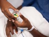 Nurse handing hospital patient a cup of pills