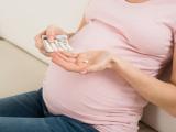Pregnant woman holding pills