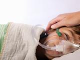 Sick child wearing oxygen mask