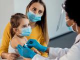 Girl getting bandaid after shot in arm