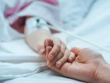 Parent holding child's hand in hospital