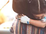 Sick girl hugging mom in hospital