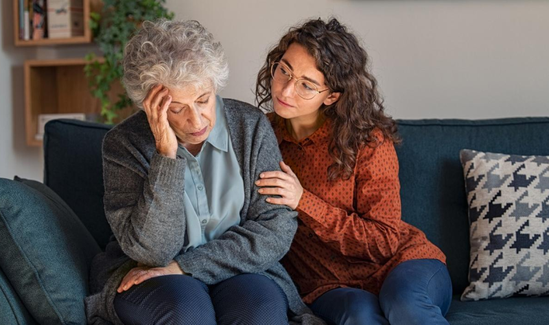 Daughter comforting confused mother