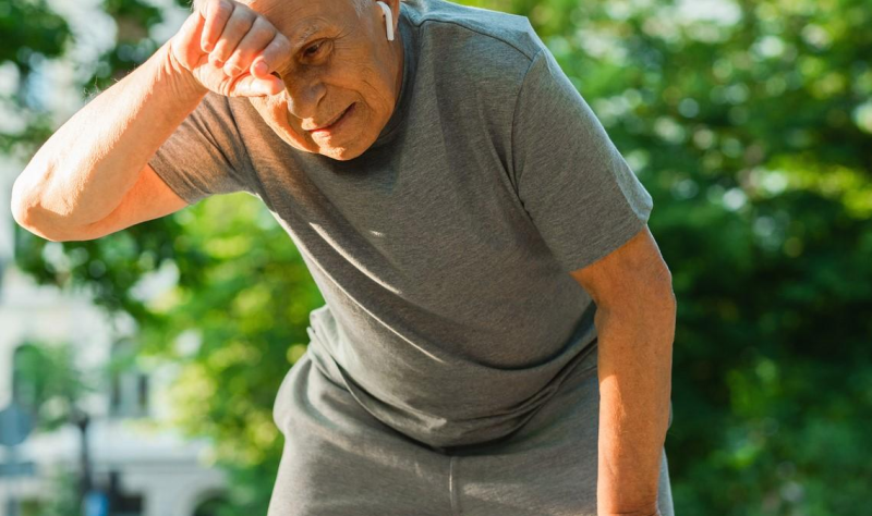 Older man wiping brow