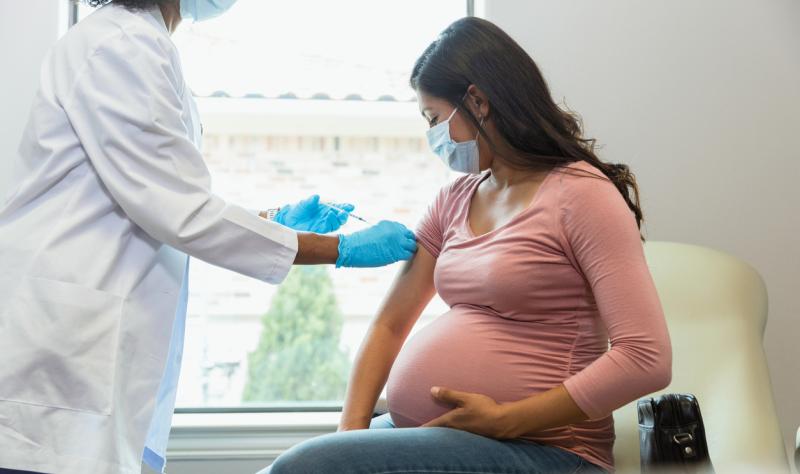 A pregnant woman receives a COVID-19 vaccination.