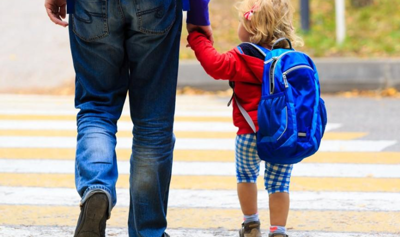 Preschooler walking to school with dad