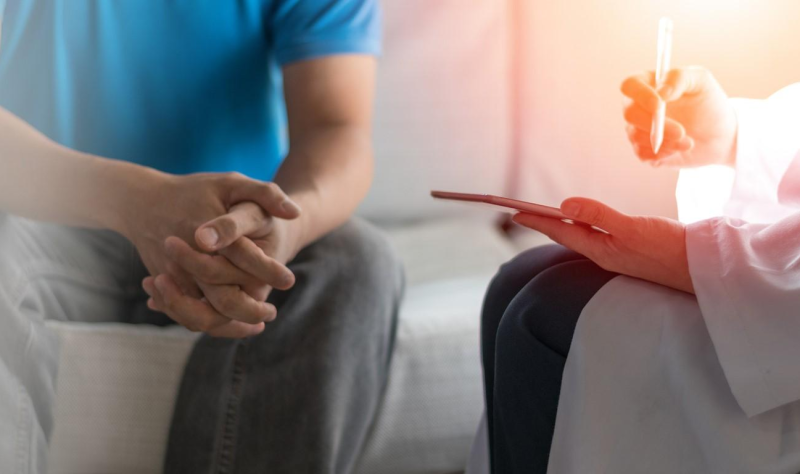 Young man talking with doctor