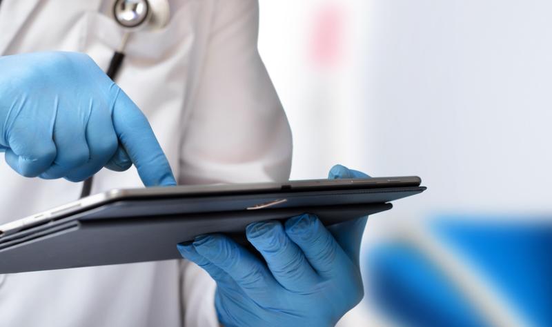Man in hospital and doctor looking at tablet
