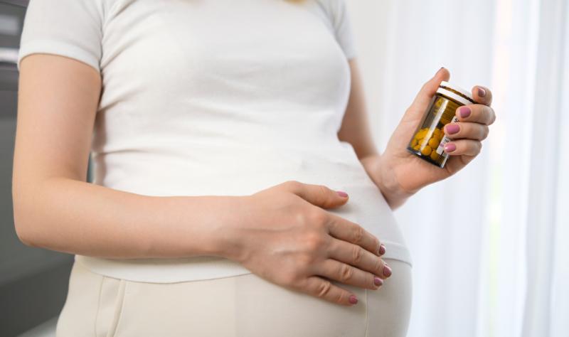 Pregnant women holding bottle of pills