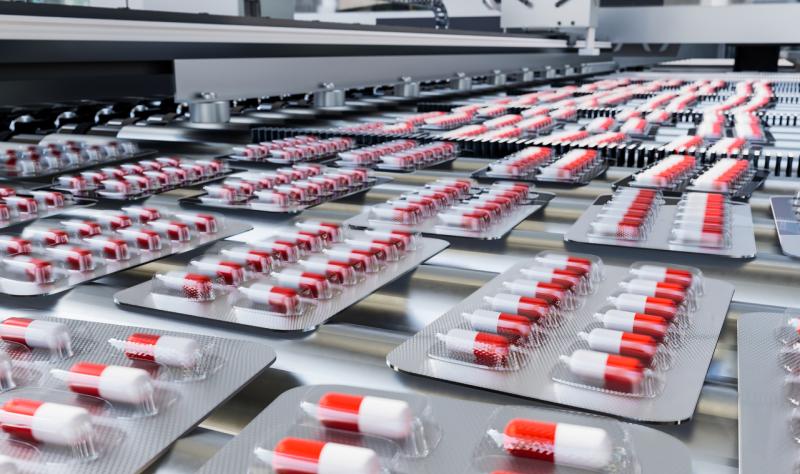 Red and white capsules in blister packs on production line