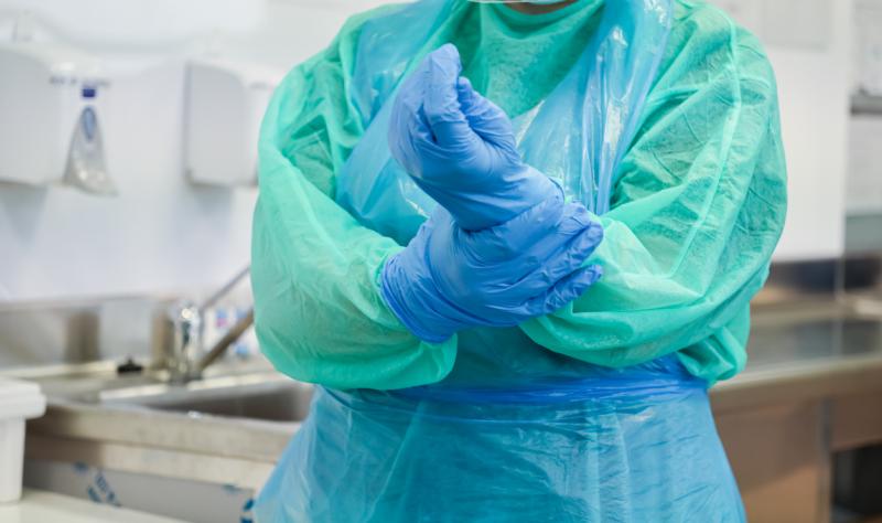 Healthcare worker in gown and gloves