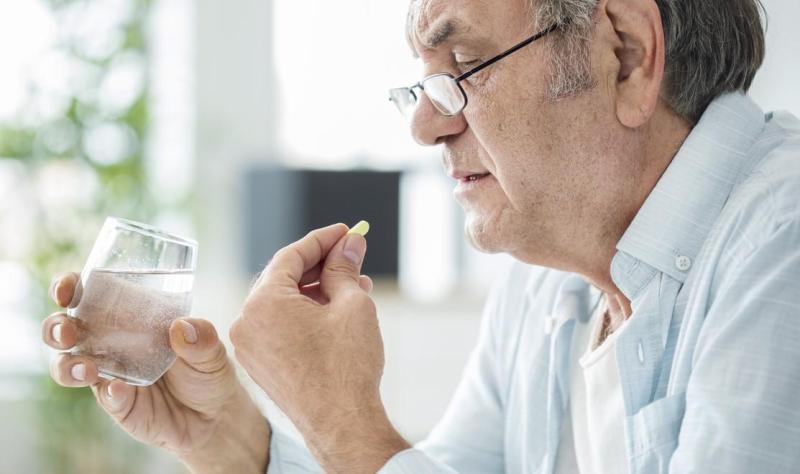 Older man taking pill